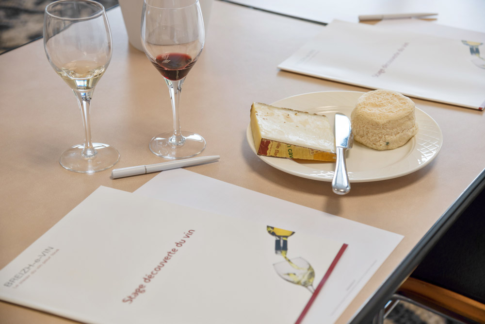 Photo d'un dossier papier "stage découverte du vin", de 2 fromages et 2 verres de vins pendant un cours dégustation des vins à Brest