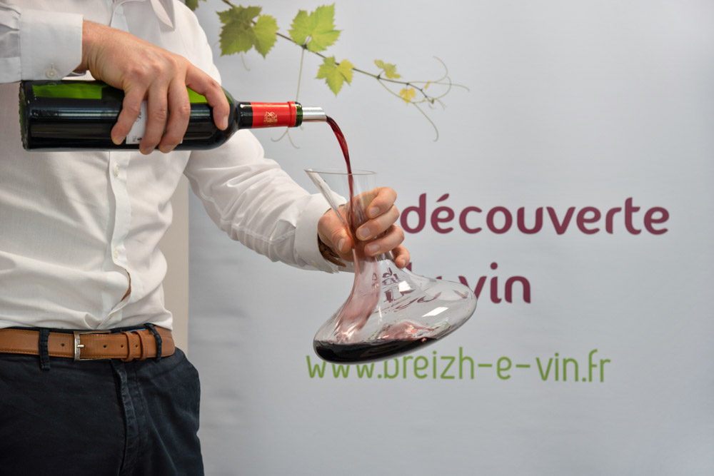 Tristan de BREIZH-e-VIN qui sert du vin rouge en carafe lors d'un atelier dégustation du vin à Rennes
